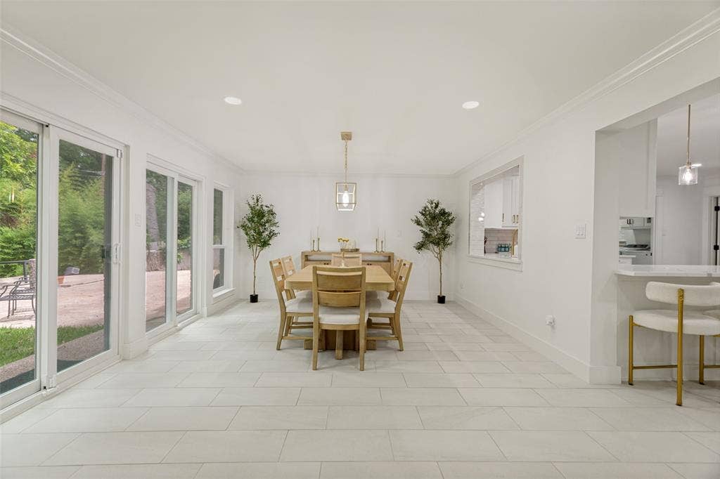 4316 Springbranch Drive, Benbrook, TX 76116 Recessed lighting, crown molding, white tile flooring, sliding glass doors, and a decorative pendant light