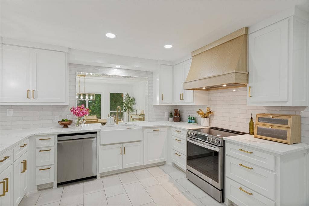 4316 Springbranch Drive, Benbrook, TX 76116 White shaker cabinetry with gold-tone hardware, stainless steel appliances, a farmhouse-style sink, white subway tile backsplash, and recessed lighting