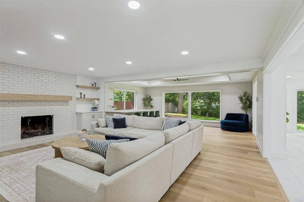 4316 Springbranch Drive, Benbrook, TX 76116 White brick fireplace with wood mantel, built-in cabinetry, recessed lighting, wood-finish flooring, and expansive windows