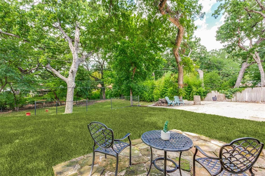 4316 Springbranch Drive, Benbrook, TX 76116 Stone patio with a manicured lawn, established trees, and a gravel area