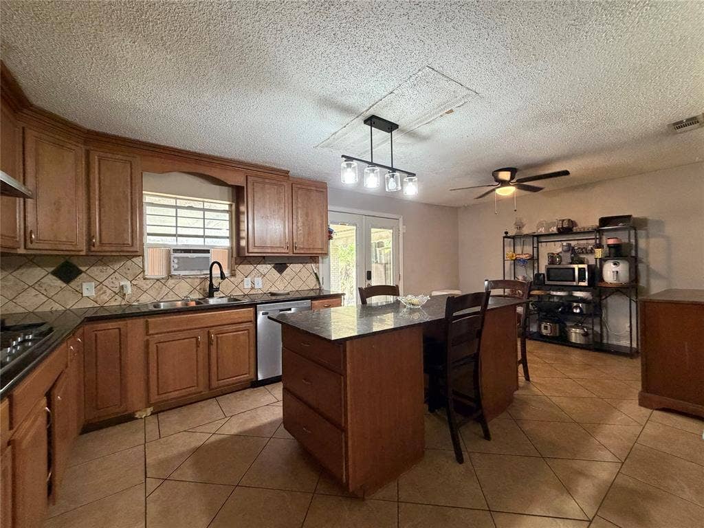 1333 Springlake Drive, Dallas, TX 75217 Large eat-in kitchen with stainless steel appliances, granite countertops, and island.