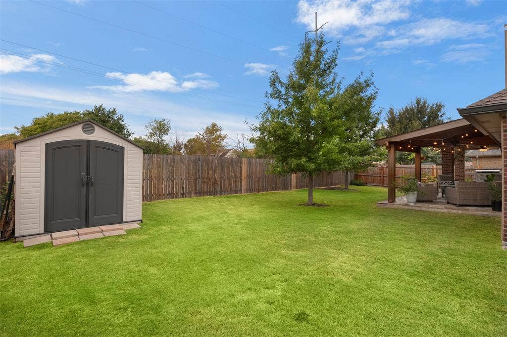 2189 Liriope Lane, Waxahachie, TX 75165 Spacious fenced yard with mature shade trees and a separate storage shed.