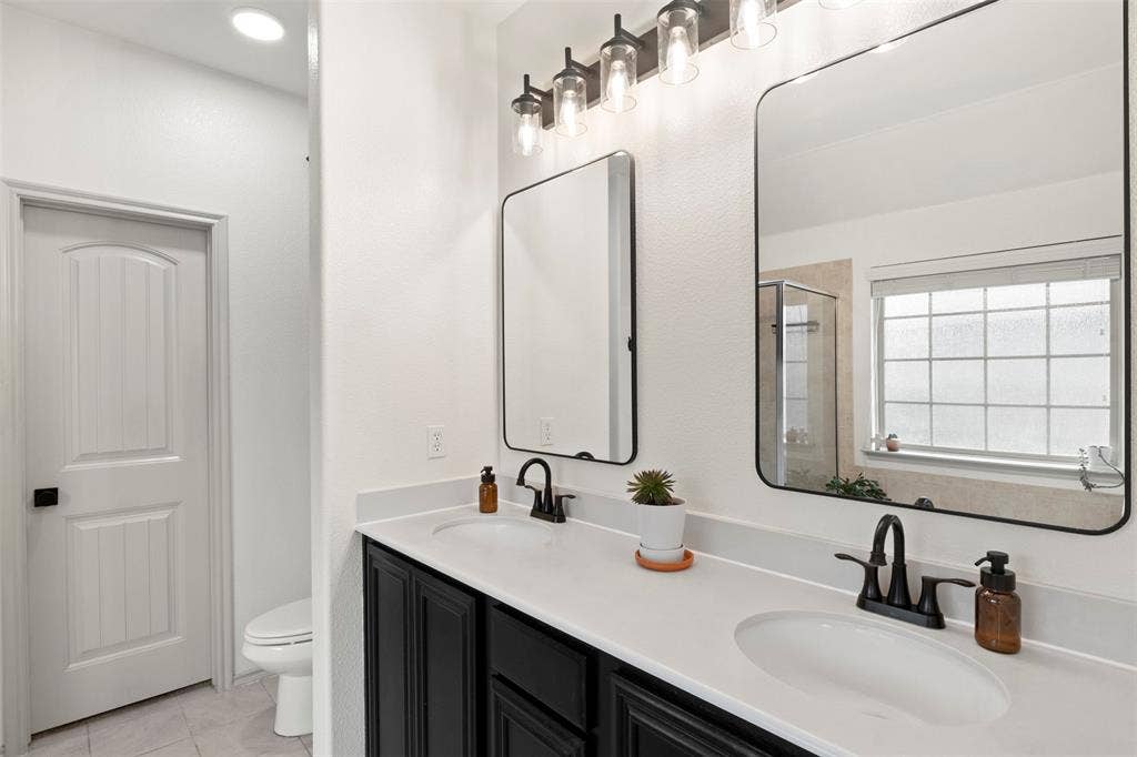 2189 Liriope Lane, Waxahachie, TX 75165 The long dual-sink vanity provides valuable counter space and storage, complemented by updated mirrors, lighting and matte-black fixtures.