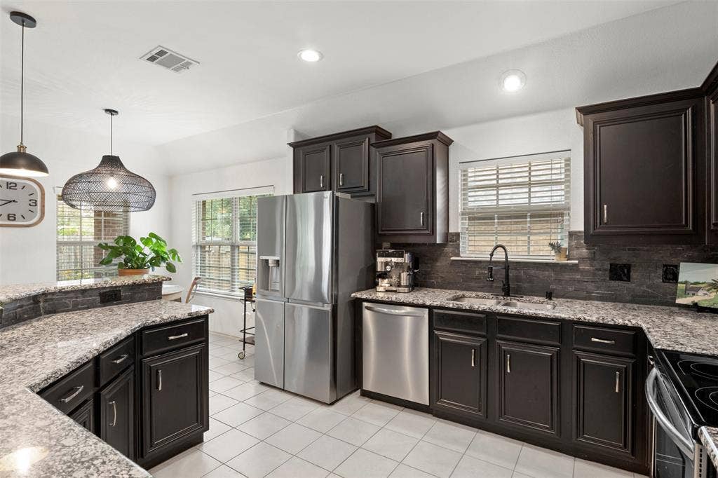 2189 Liriope Lane, Waxahachie, TX 75165 Designed for everyday function, the kitchen offers abundant cabinetry and counter space, stainless steel appliances and bar seating, all within easy reach of the adjoining living area.