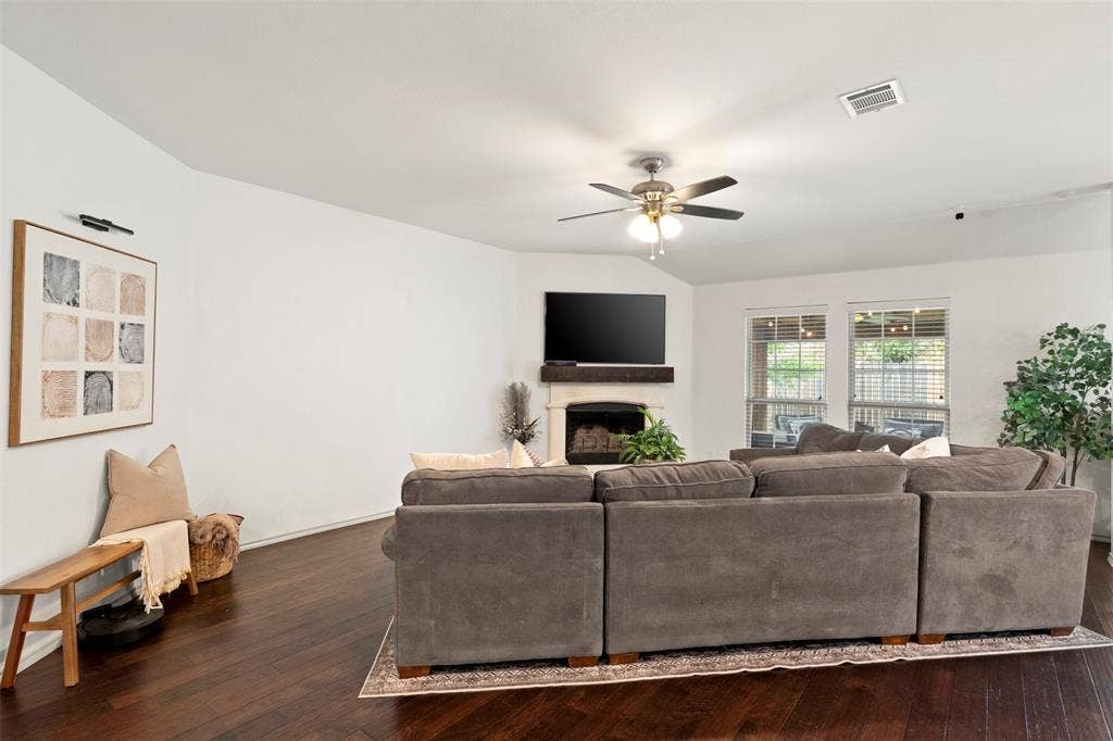 2189 Liriope Lane, Waxahachie, TX 75165 Fresh paint and dark flooring give the living room a clean, updated backdrop, while the wide arched opening maintains an easy connection to the bedroom hallway and rest of the home.
