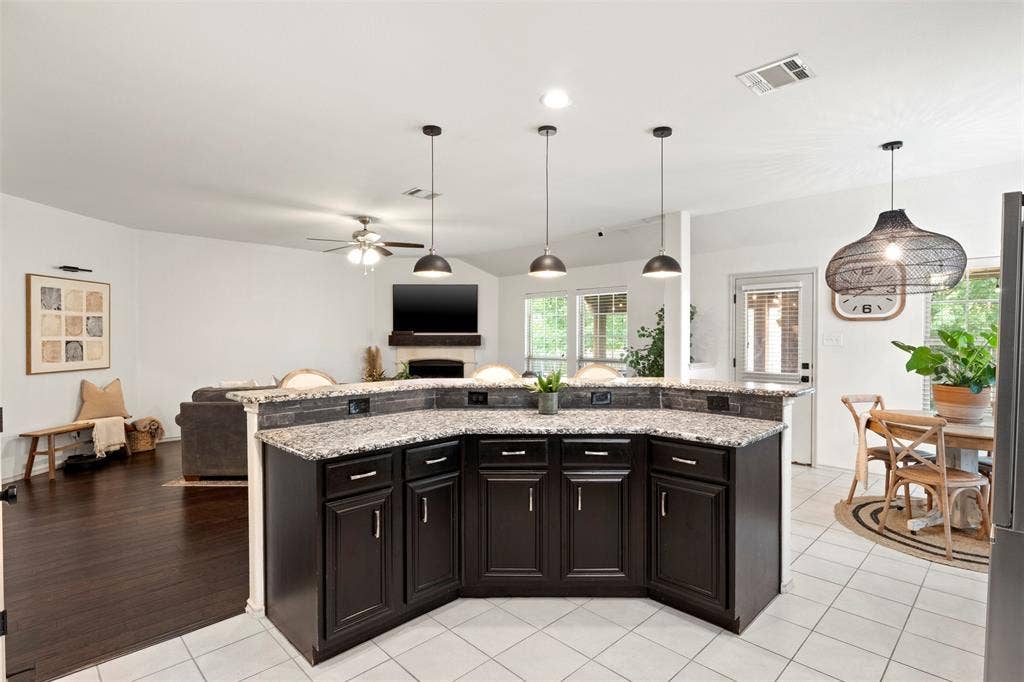 2189 Liriope Lane, Waxahachie, TX 75165 This view really shows the OPEN-CONCEPT LAYOUT—the large wraparound counter connects the kitchen to the living area while providing generous prep space and additional seating