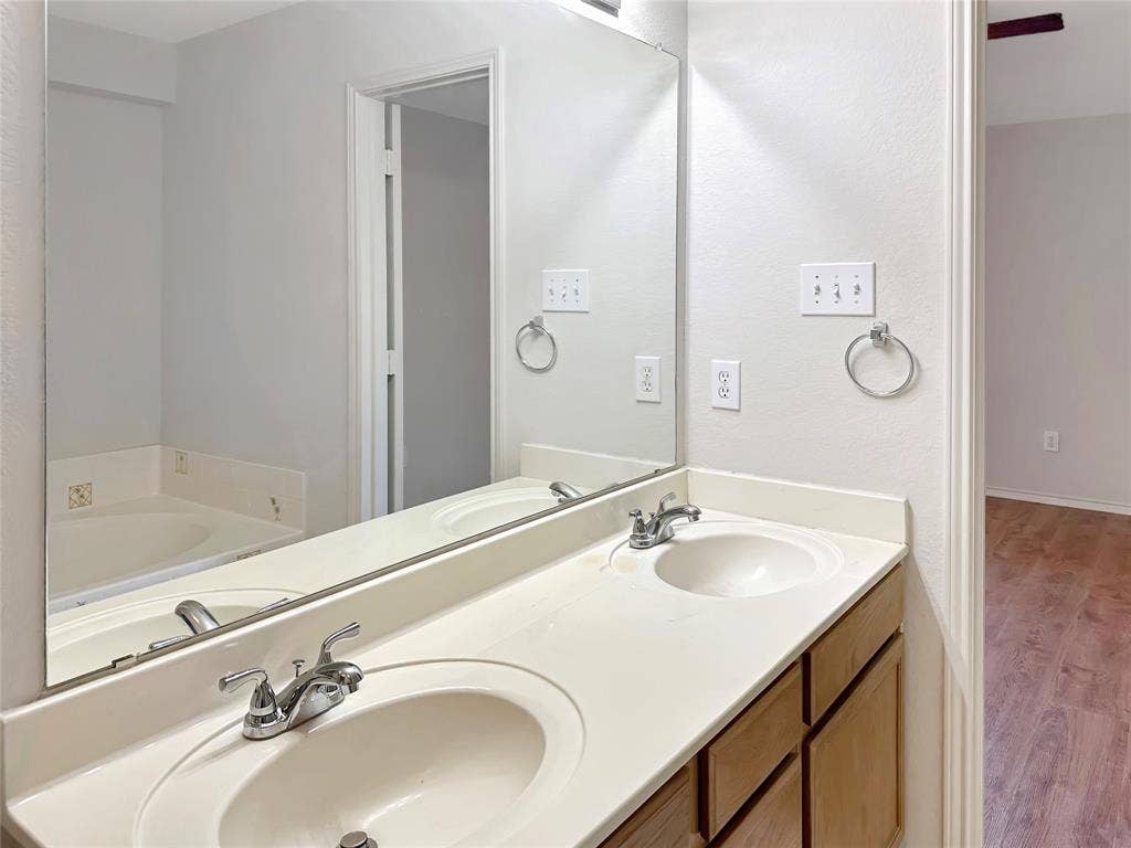 3457 Newgate Street, Midlothian, TX 76065 Bathroom with wood finished floors, double vanity, and a garden tub