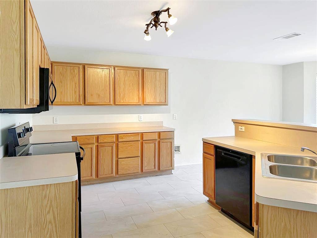 3457 Newgate Street, Midlothian, TX 76065 Kitchen with electric stove, black dishwasher, light countertops, and light tile patterned floors