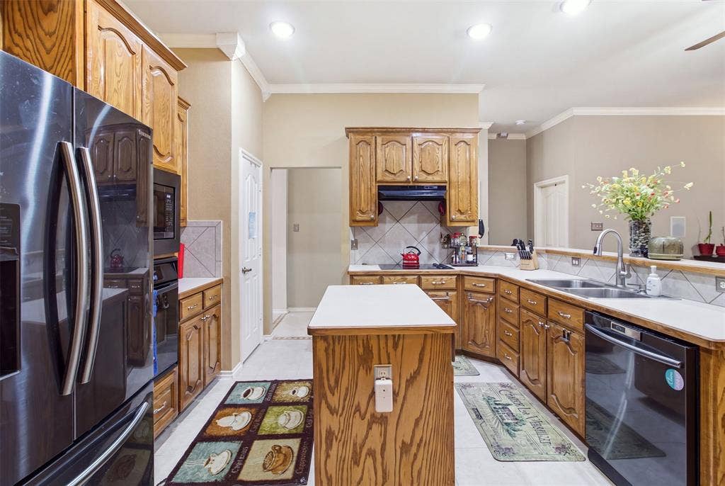 1112 Badbury Lane, Grand Prairie, TX 75052 Kitchen featuring wood-finish cabinetry, white countertops, a stainless steel sink, and a built-in oven