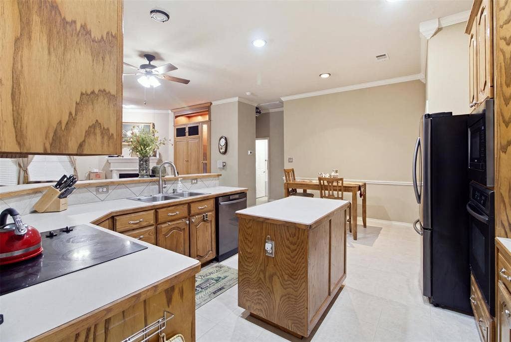 1112 Badbury Lane, Grand Prairie, TX 75052 Kitchen with wood-finish cabinetry, light-toned countertops, tile backsplash, and stainless steel dishwasher