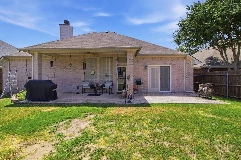 1112 Badbury Lane, Grand Prairie, TX 75052 Brick exterior with a covered patio, additional patio space, and sliding glass door access