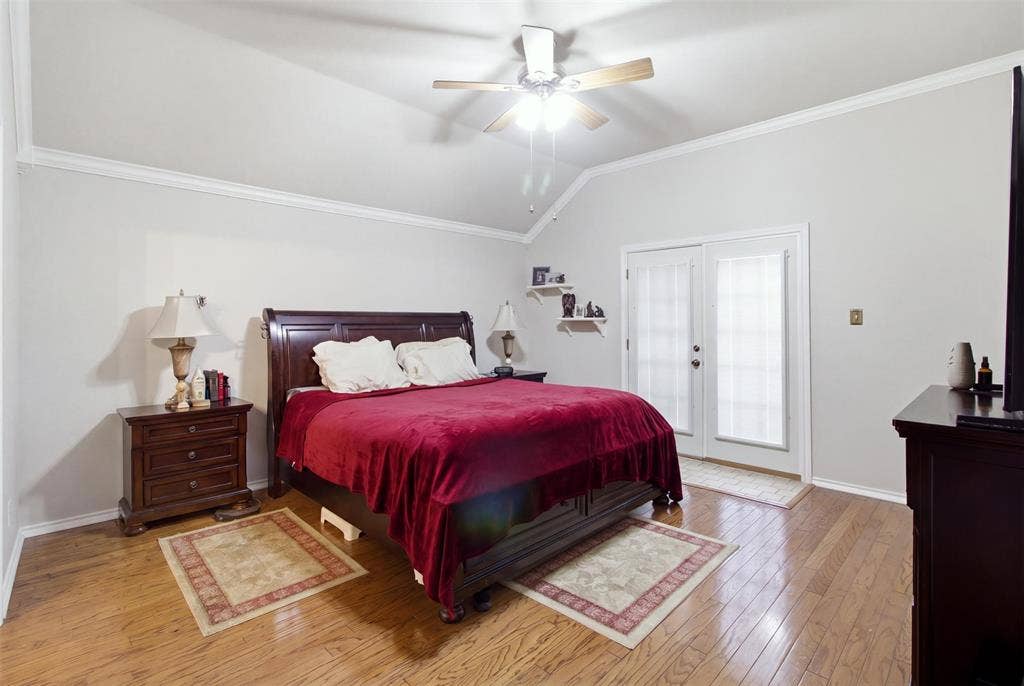 1112 Badbury Lane, Grand Prairie, TX 75052 Vaulted ceiling with crown molding, wood-finish flooring, ceiling fan with light fixture, and double glass-paneled doors with blinds