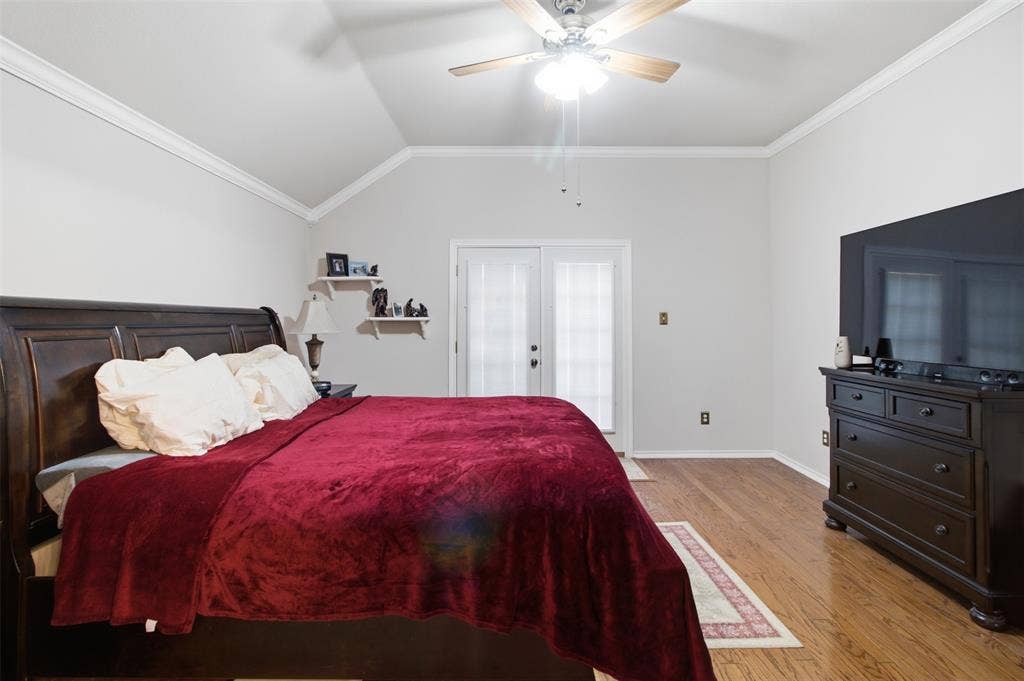 1112 Badbury Lane, Grand Prairie, TX 75052 Vaulted ceiling with crown molding, wood-finish flooring, and a ceiling fan