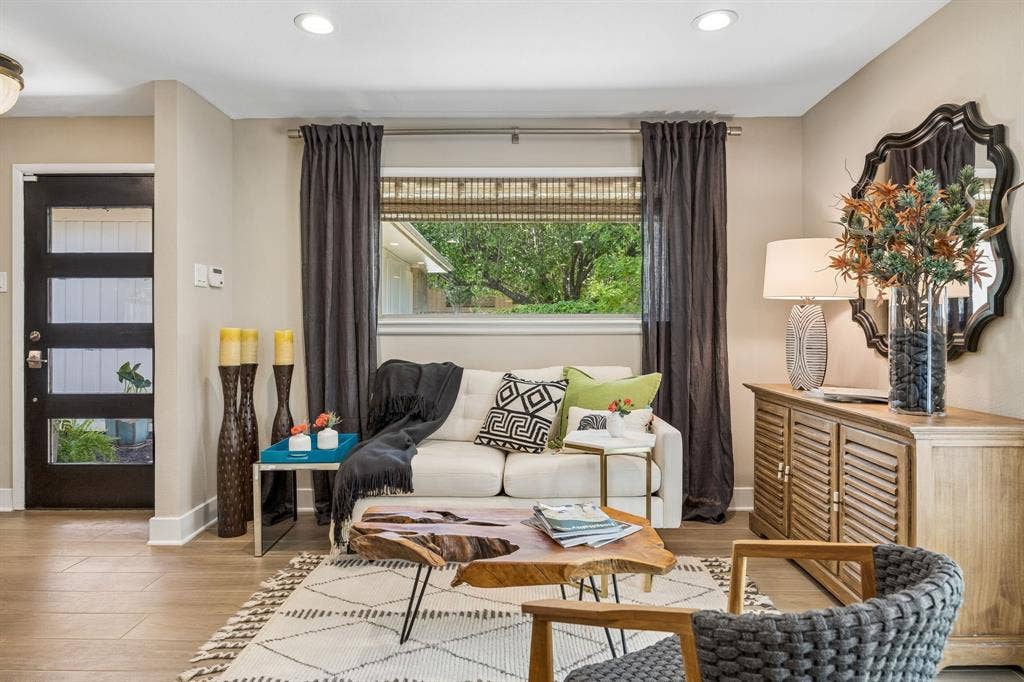 Wood-finish flooring throughout, recessed ceiling lighting, and a modern entry door with horizontal glass panels