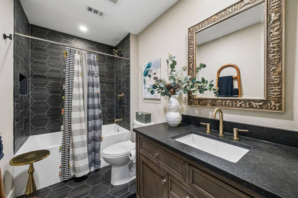 Hexagonal tile flooring and shower surround with Black granite countertops