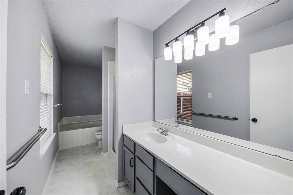 117 Palomino Lane, Krum, TX 76249 This primary ensuite bathroom features great counter space and a desk for your convenience