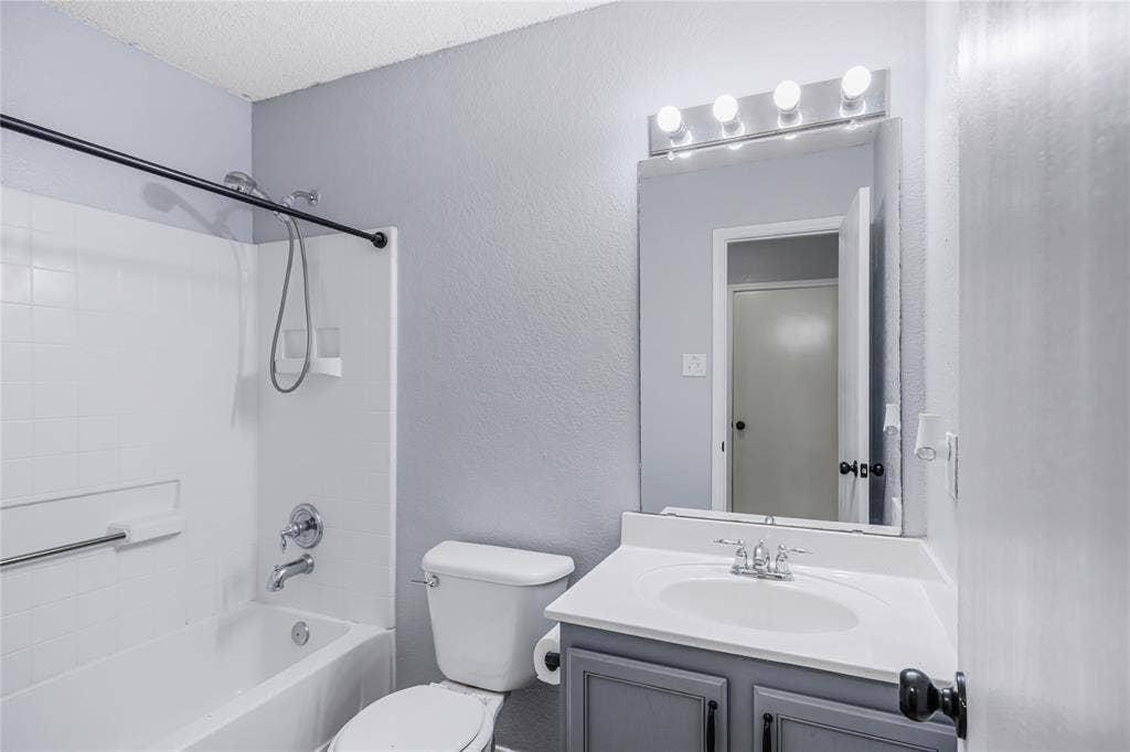117 Palomino Lane, Krum, TX 76249 This secondary bathroom with a single sink and modern lighting and laminate flooring.