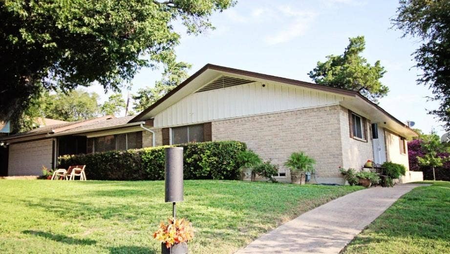 4315 Woodstock Drive, Dallas, TX 75232 Brick ranch home with an expansive manicured lawn bordered by mature trees and established landscaping