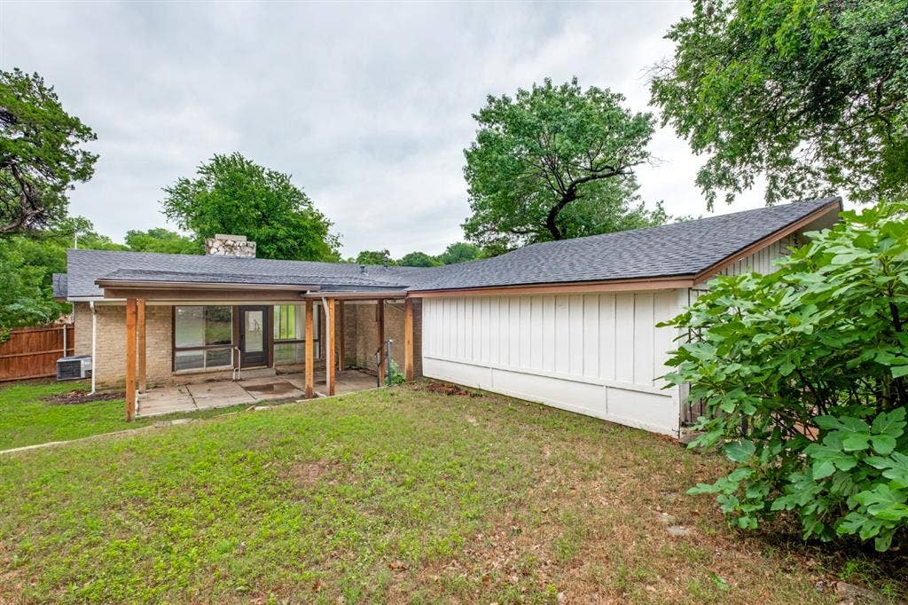4315 Woodstock Drive, Dallas, TX 75232 Single-story residence with a modern exterior featuring metal siding and a pitched roof