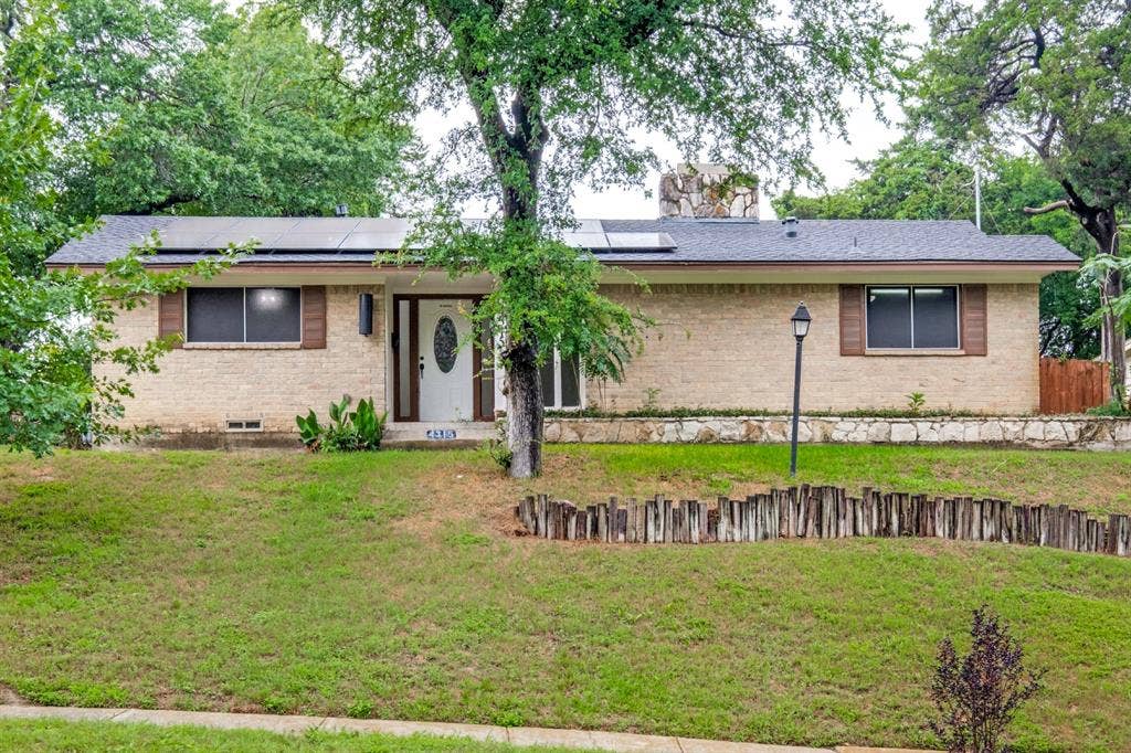 4315 Woodstock Drive, Dallas, TX 75232 Brick exterior with a gabled roof and solar panels