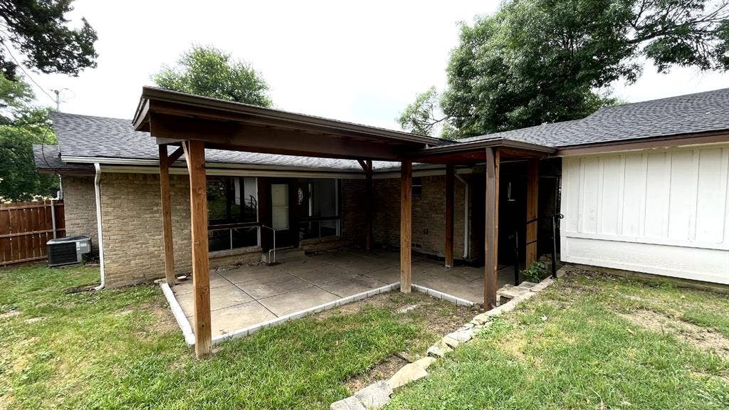 4315 Woodstock Drive, Dallas, TX 75232 Covered concrete patio with wood support beams and brick exterior