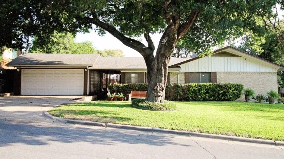 4315 Woodstock Drive, Dallas, TX 75232 Single-story residence featuring a brick and siding exterior, attached two-car garage, and a sloped roofline
