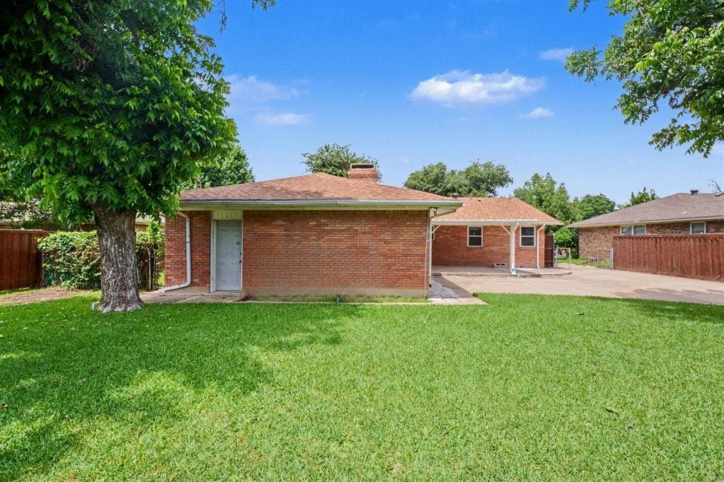 1114 Glouchester Drive, Garland, TX 75040 Expansive lawn, mature tree, brick exterior, covered patio, and paved driveway