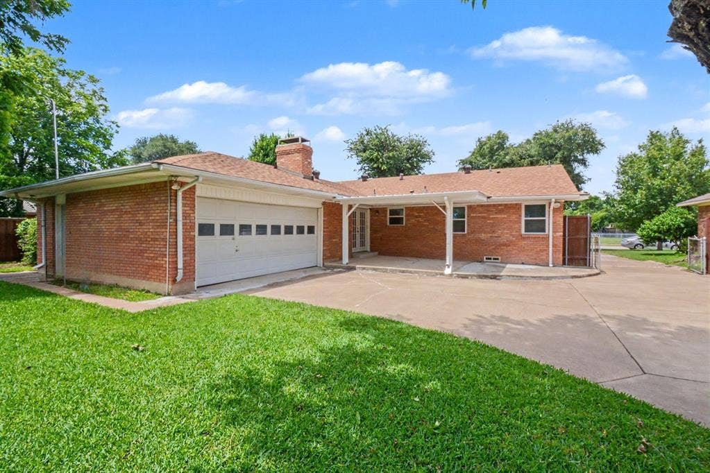 1114 Glouchester Drive, Garland, TX 75040 Brick exterior with an attached garage, covered patio, and a paved driveway