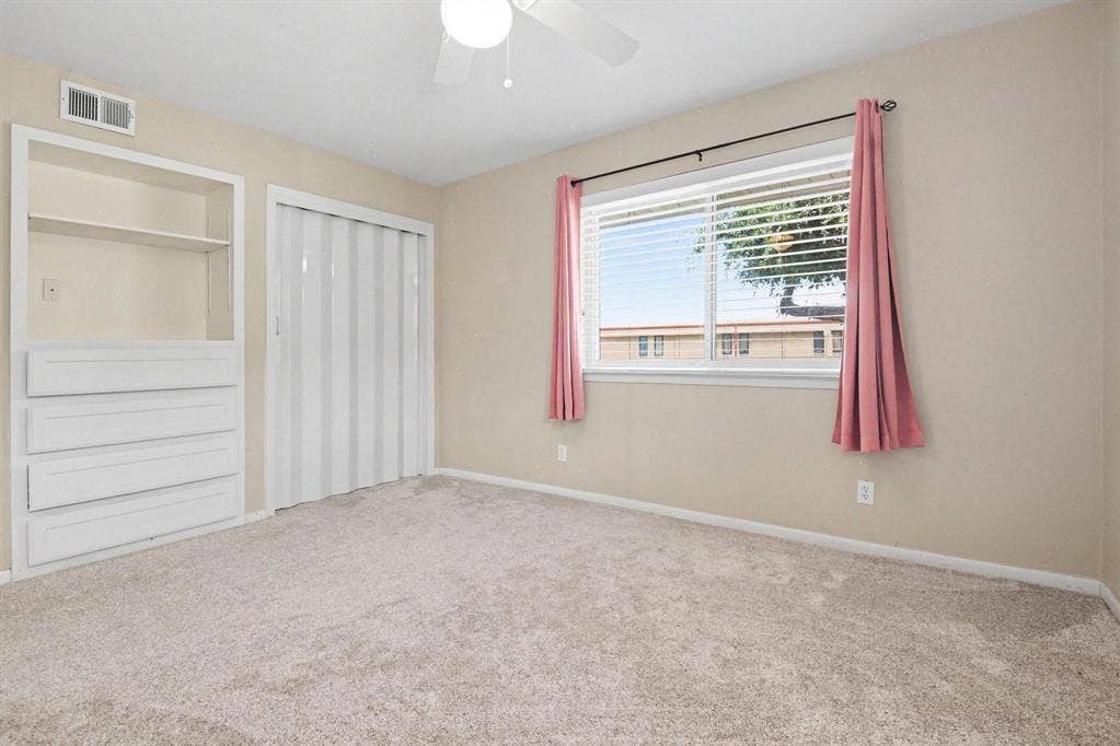1114 Glouchester Drive, Garland, TX 75040 Recessed built-in shelving with drawers, accordion closet door, and light-colored carpeting