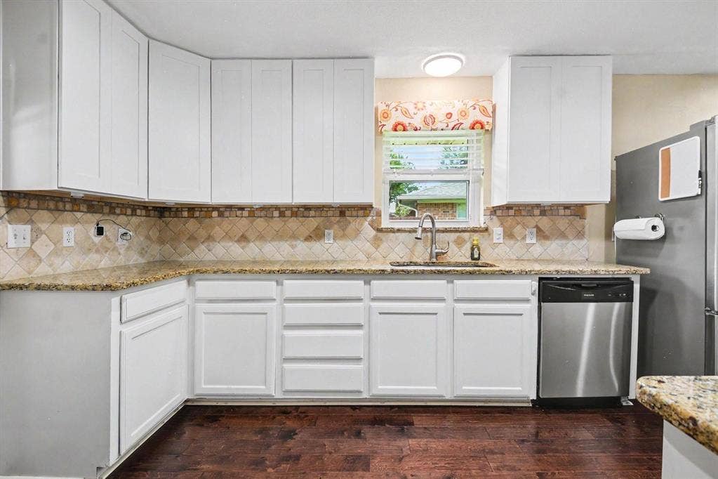 1114 Glouchester Drive, Garland, TX 75040 Kitchen featuring white cabinetry, granite countertops, tile backsplash, stainless steel dishwasher, and wood-finish flooring