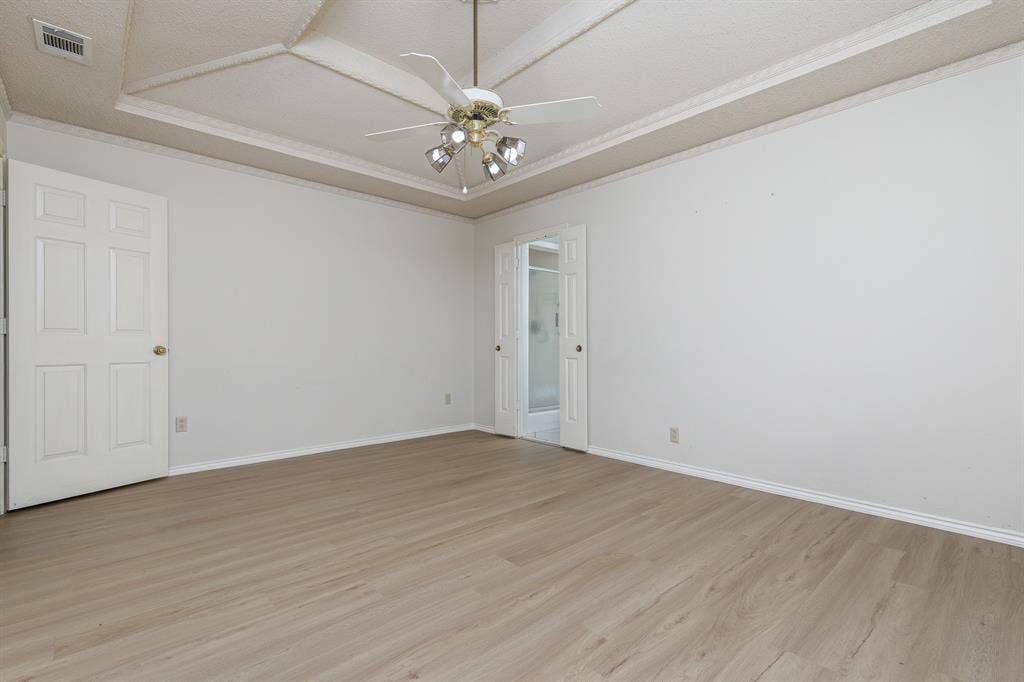 2526 Willowdale Drive, Carrollton, TX 75006 Recessed ceiling with decorative trim, wood-finish flooring, ceiling fan with integrated lighting, and panel doors