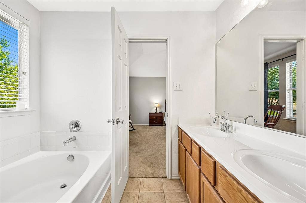 Dual vanity with integrated sinks, wood-finish cabinetry, and a full-width mirror