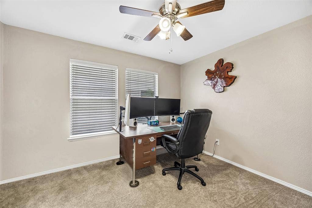 Carpeted room with two windows, horizontal blinds, and a ceiling fan with light fixture