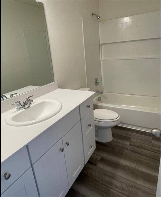 1903 Marquette Drive, Princeton, TX 75407 Vanity with an integrated sink and chrome fixtures, white cabinetry with chrome hardware, wood-finish flooring, and a shower-over-tub combination with a subway-tiled surround