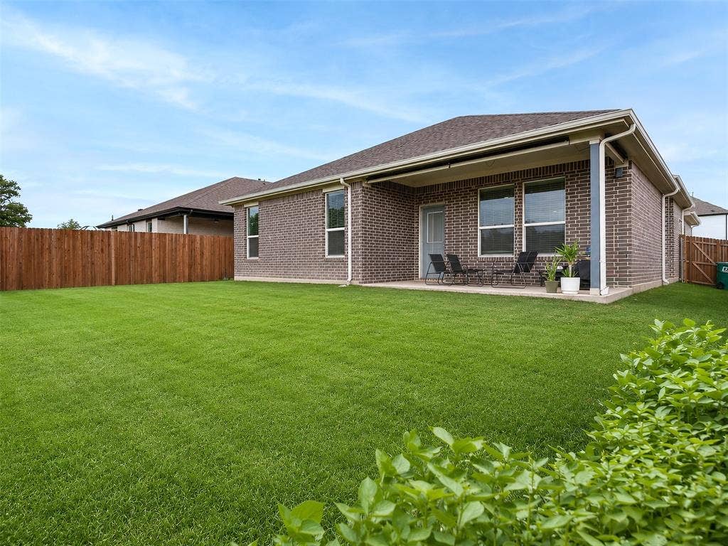 2504 Wren Lane, Denton, TX 76205 Expansive backyard with a manicured lawn, full privacy fencing, and a covered patio