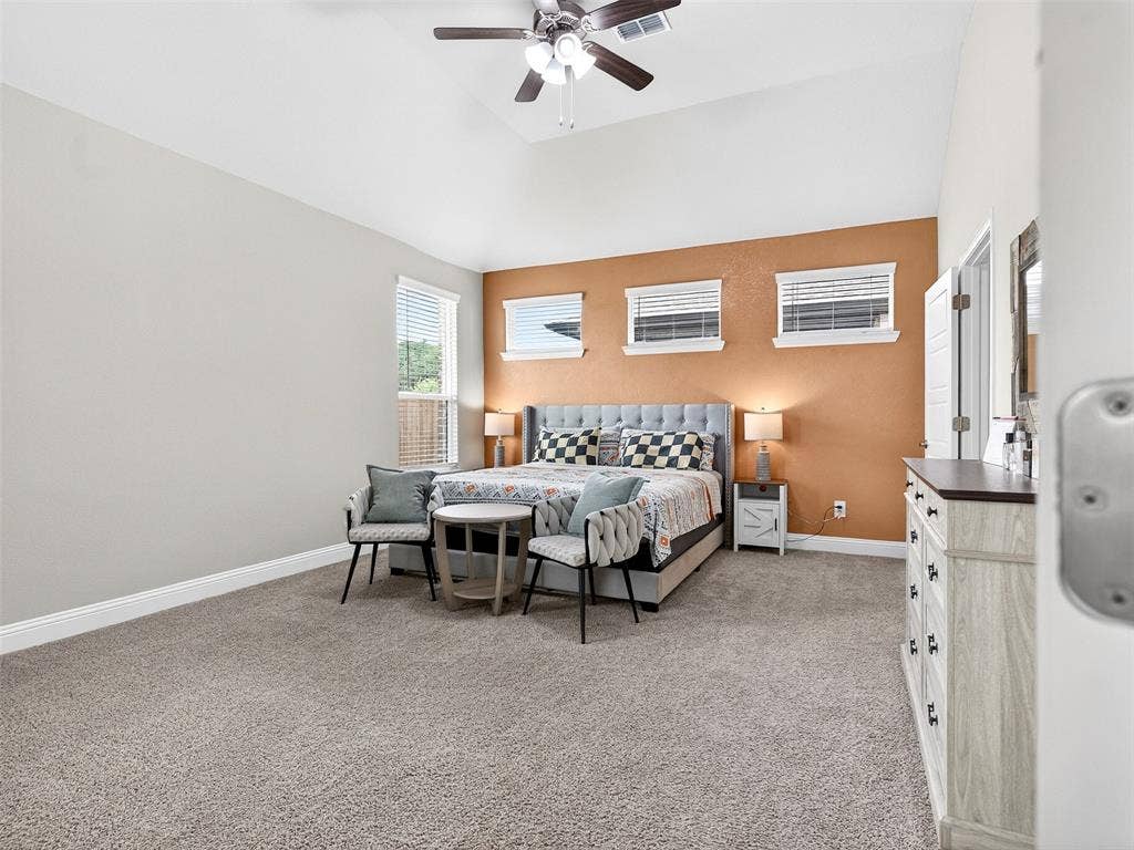 2504 Wren Lane, Denton, TX 76205 Vaulted ceiling, ceiling fan, carpet flooring, multiple windows, and a built-in dresser