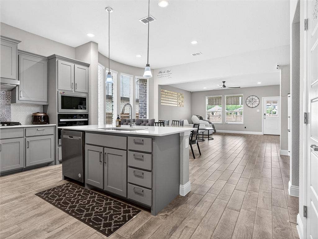 2504 Wren Lane, Denton, TX 76205 Open-concept kitchen and living area featuring wood-finish flooring, recessed lighting, and a kitchen island with pendant lighting