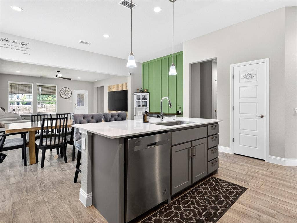 2504 Wren Lane, Denton, TX 76205 Kitchen island with white countertop, undermount sink, and stainless steel dishwasher
