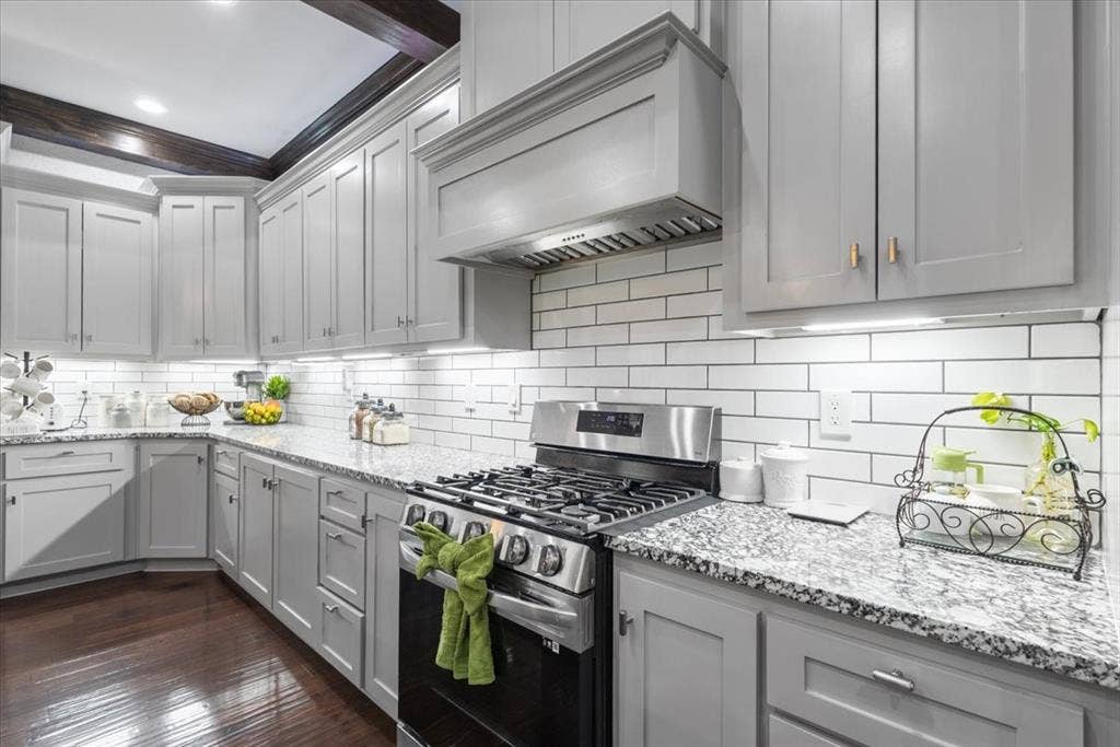 16136 County Road 1134=, Tyler, TX 75709 Light gray cabinetry with gold-tone hardware, granite-style countertops, subway tile backsplash, and wood-finish flooring