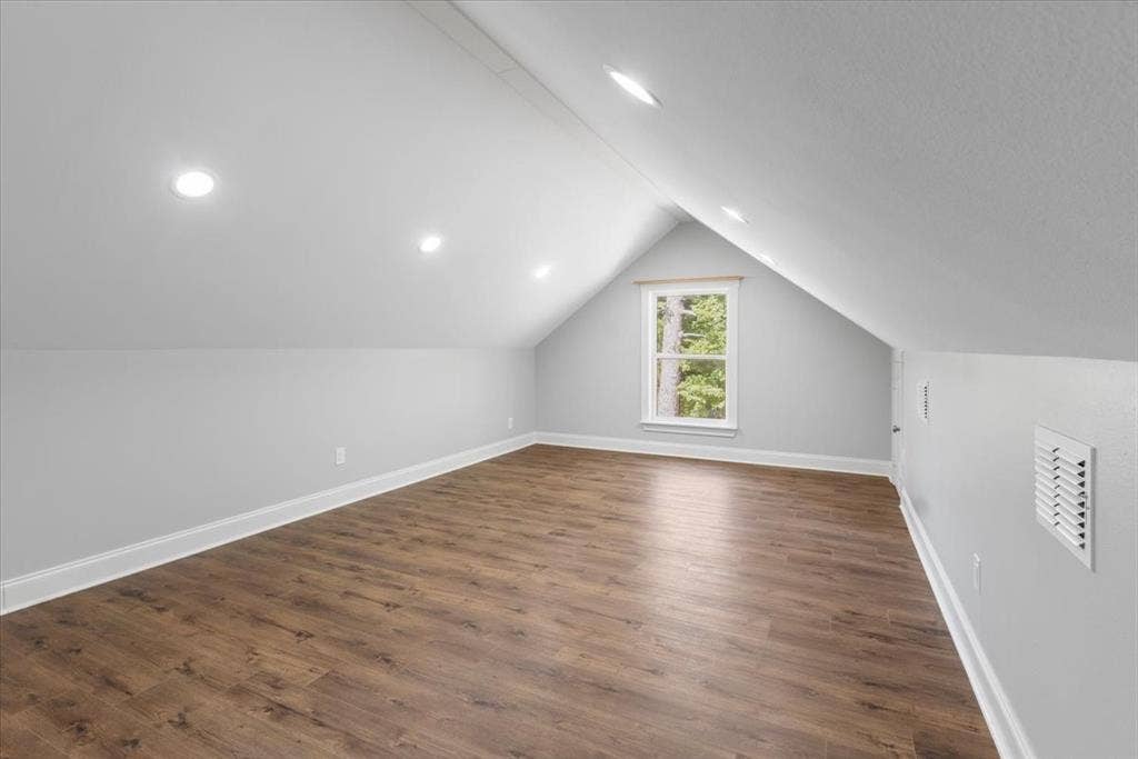 16136 County Road 1134=, Tyler, TX 75709 Bright attic space with sloped ceilings, wood-finish flooring, recessed lighting, and a prominent window
