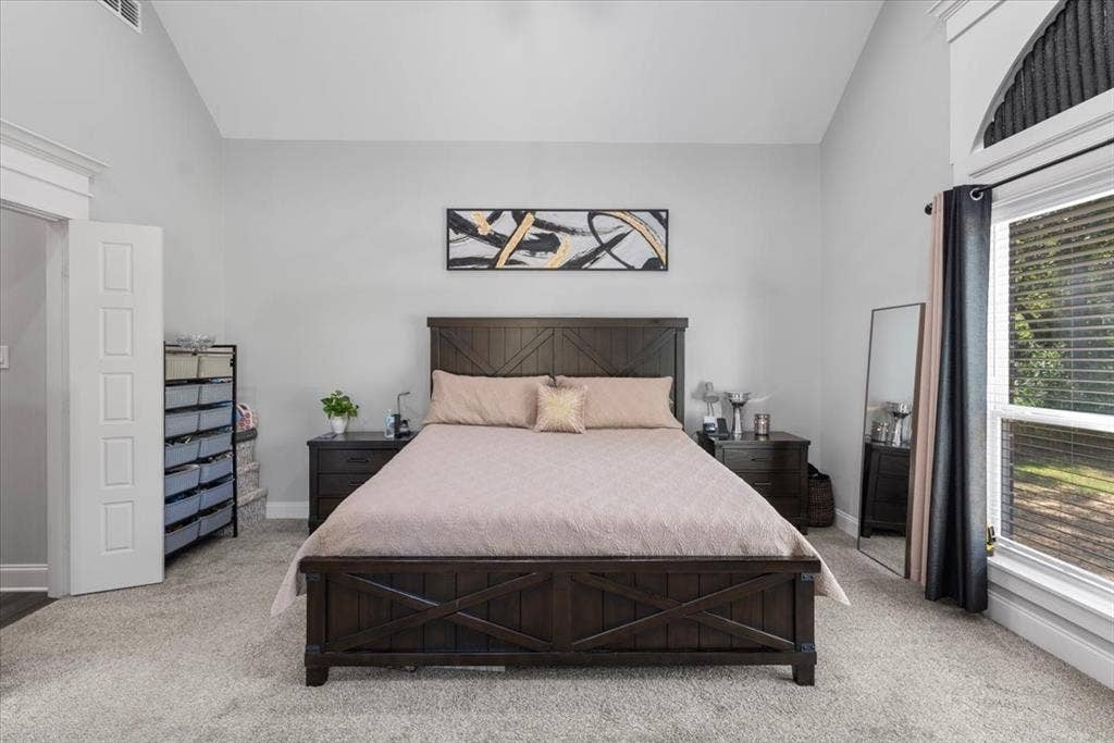 16136 County Road 1134=, Tyler, TX 75709 Vaulted ceiling, arched transom window, wood-finish bed frame, nightstands with drawer storage, and carpeted flooring