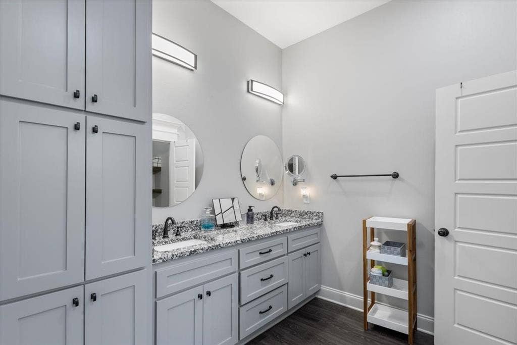 16136 County Road 1134=, Tyler, TX 75709 Dual vanity with undermount sinks, speckled countertop, and wall-mounted light fixtures