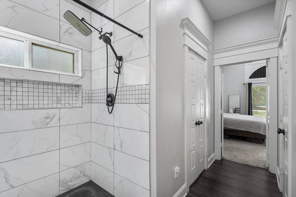 16136 County Road 1134=, Tyler, TX 75709 Shower featuring white tile walls, black grid accent tile, a built-in shower niche, and a fixed window