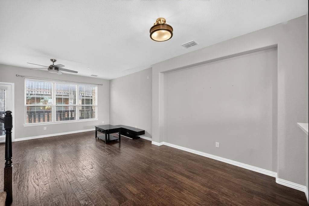 7880 Oxer Drive, Irving, TX 75063 Hardwood-finish flooring, recessed wall niche, ceiling fan, and prominent window with blinds
