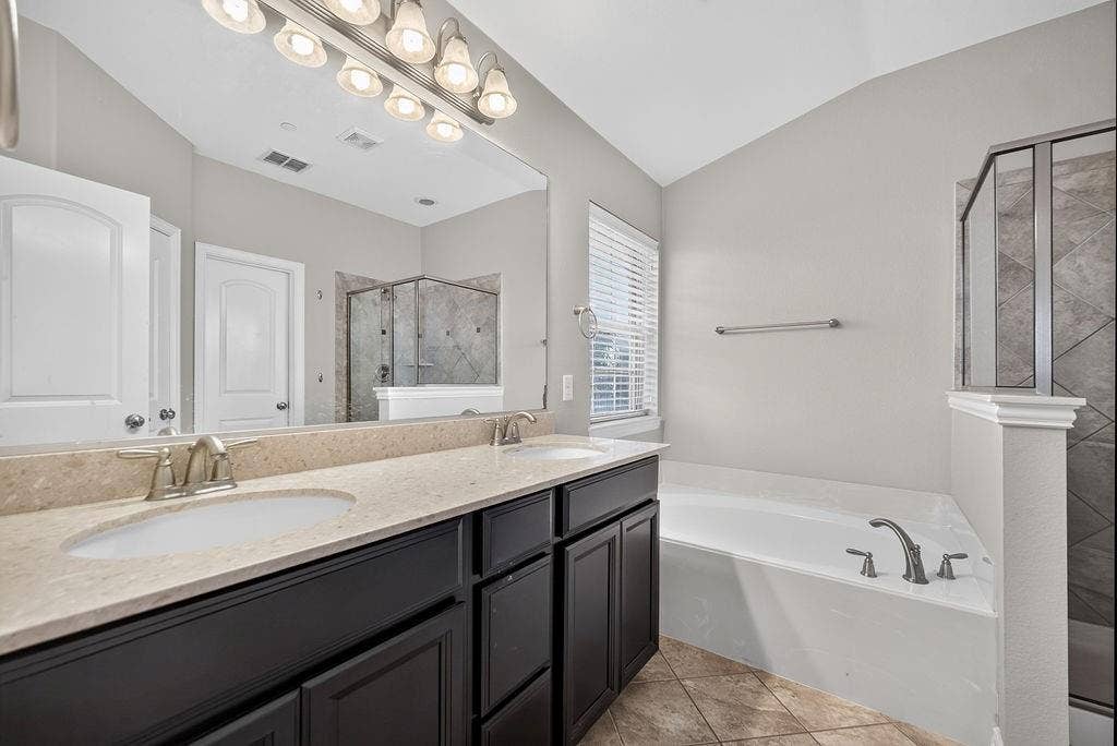 7880 Oxer Drive, Irving, TX 75063 Dual vanity with integrated sinks, light-toned countertop, and dark wood-finish cabinetry
