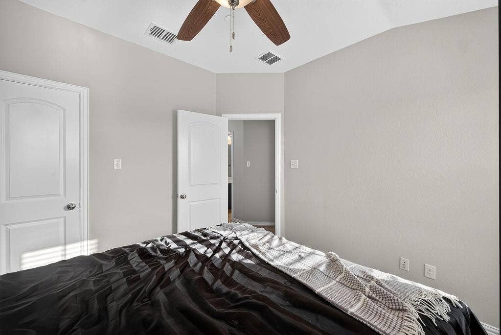 7880 Oxer Drive, Irving, TX 75063 Vaulted ceiling with a wood-finish ceiling fan, neutral wall paint, and white paneled doors