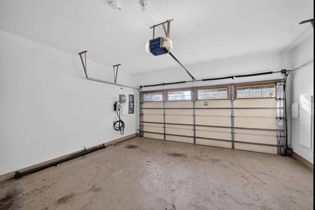 7880 Oxer Drive, Irving, TX 75063 Garage featuring an automatic opener, EV charging station, and overhead storage rails