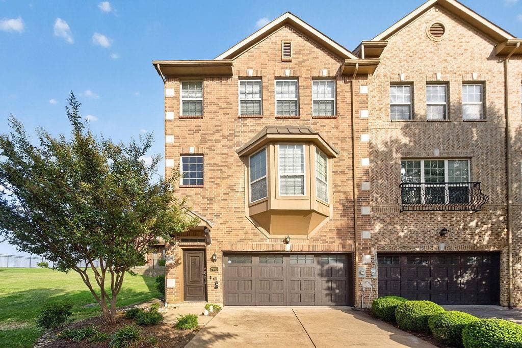 7880 Oxer Drive, Irving, TX 75063 Brick exterior with a prominent bay window, two-car garage, and an ornamental balcony