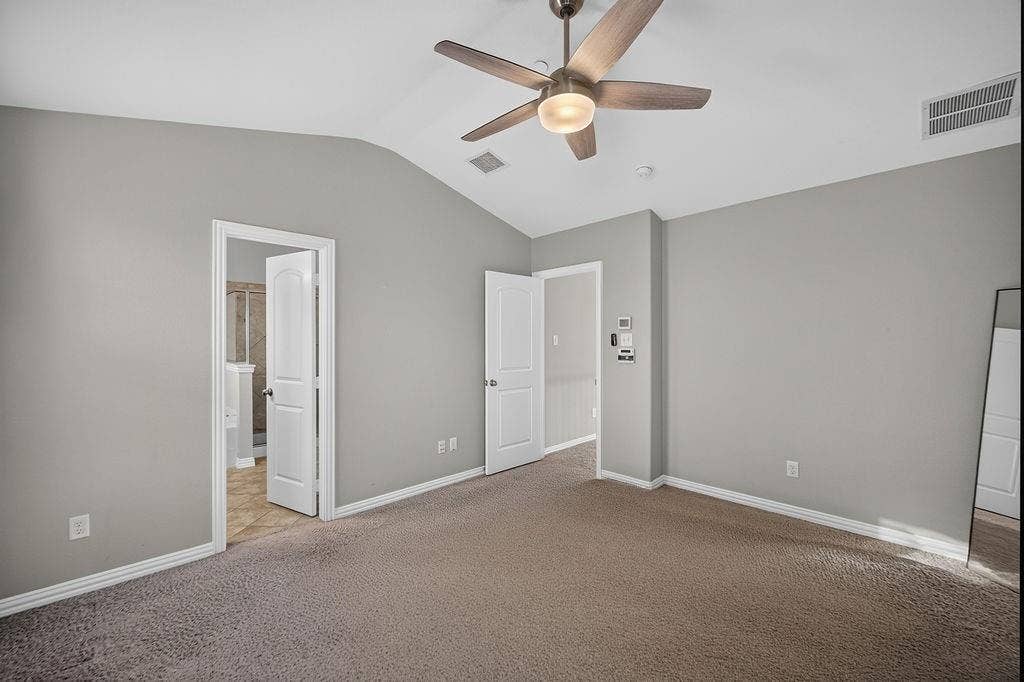 7880 Oxer Drive, Irving, TX 75063 Vaulted ceiling with an attached ceiling fan and light fixture, neutral grey wall paint, and brown carpet flooring
