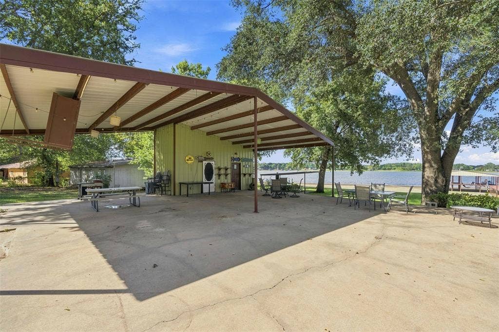 18404 Pine Drive, Eustace, TX 75124 Expansive covered pavillion with concrete flooring, supported by a metal frame, offering direct waterfront access